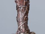 a silver vase with three apples on a glass table