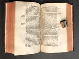 an open book that has a small piece of paper sticking out of it