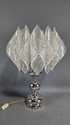 a glass table lamp with a metal base and a glass shade