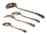four spoons and a spoon rest on a white surface