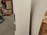a white refrigerator sitting on a pallet in a warehouse