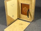 un livre ouvert sur lequel figure un blason