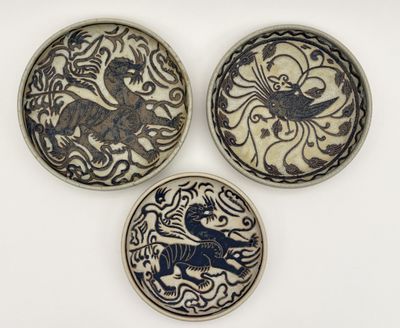trois assiettes ornées de motifs sont posées sur une surface blanche