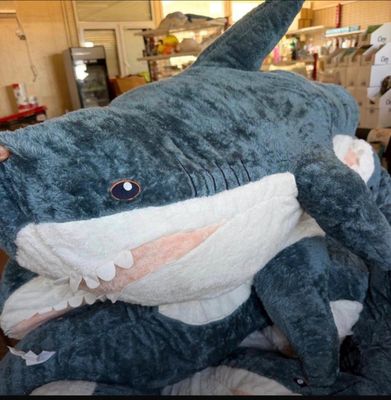 un grand requin en peluche posé sur un lit