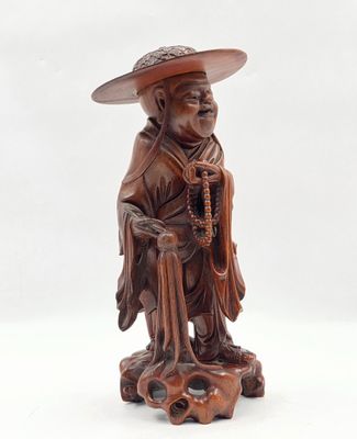 une image représentant la statue d'un homme coiffé d'un chapeau et tenant une canne