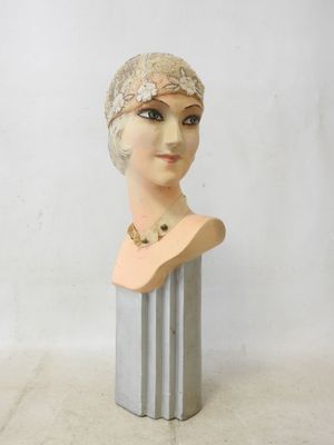 bust of a woman wearing a head scarf on top of a metal stand