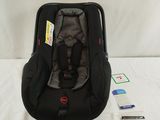 a baby car seat that is sitting on a bed
