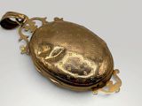an image of a gold locke on a chain with a bird on it