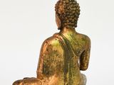 statue of a seated buddha sitting on a white surface