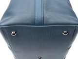 a close up of a blue leather bag on a white background