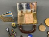 a small case with a mirror, a purse, a book, and other items