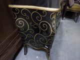 a black and gold chair in a room next to a cabinet