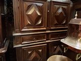 une grande armoire en bois sur laquelle est posé un bol en métal