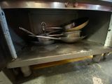 pots and pans are sitting on a shelf in a kitchen