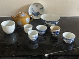 a black table with a bunch of cups and a teapot on it
