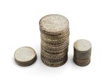 plusieurs piles de pièces empilées les unes sur les autres sur une surface blanche