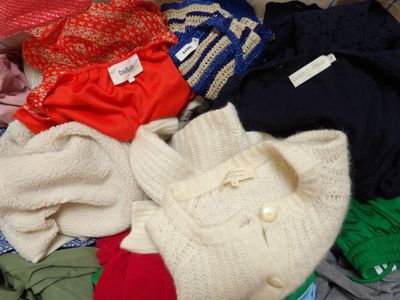a pile of clothes sitting on top of a suitcase
