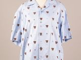 the shirt is blue and has a pattern of coffee cups on it