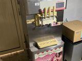 une machine posée sur le sol à côté d'une poubelle