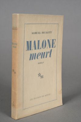 an old book sitting on top of a table on a gray surface