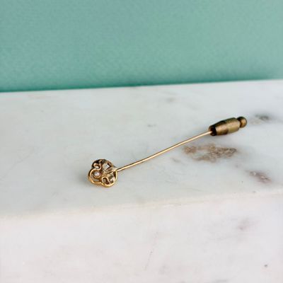 la broche en or repose sur un comptoir en marbre