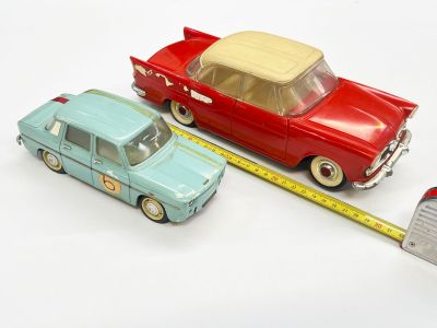 deux petites voitures posées à côté d'un mètre ruban