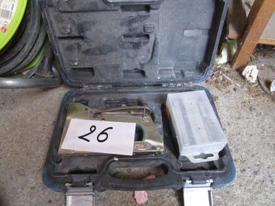 une mallette à outils posée par terre, contenant des outils