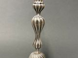 pair of antique silver candlesticks on pedestal on grey background