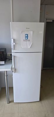 a white refrigerator in a kitchen with a laptop on the counter