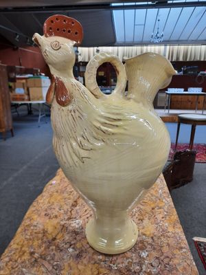 un vase blanc orné d'un oiseau, posé sur une table