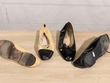 three pairs of black and yellow shoes sitting on top of a wooden table
