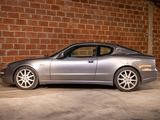 a silver sports car parked in front of a brick wall