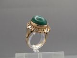Gros plan sur une bague ornée d'une pierre verte