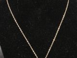 un collier en or orné d'une ancre autour du cou d'un mannequin