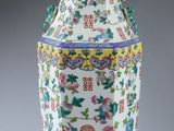 un vase blanc orné de motifs colorés sur un fond gris
