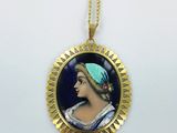 un collier plaqué or orné du portrait d'une femme portant un bandeau bleu
