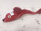 figurine de poisson rouge munie d'une étiquette, posée sur une surface en marbre