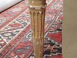 a close up of a wooden table with a red rug on the floor