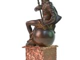 statue représentant un homme assis sur une boule, tenant une lance