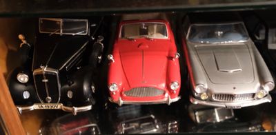 Plusieurs petites voitures sont exposées dans une vitrine.