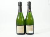 deux bouteilles de vin posées l'une à côté de l'autre sur une surface blanche