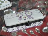 a white box with purple flowers on it sitting on a glass table