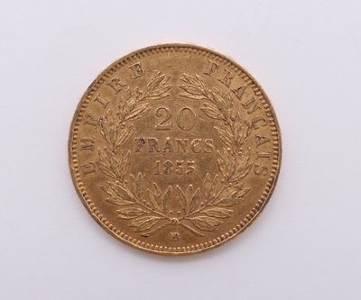gros plan d'une pièce d'or sur une surface blanche