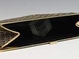 an image of a black and gold purse with a diamond inside