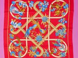 une écharpe rouge ornée de fleurs et d'oiseaux bleus