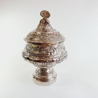 a silver container with a bird on top of it