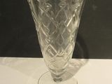 a glass vase sitting on a table with a black background