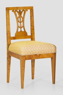 une image représentant une chaise en bois dont l'assise est recouverte d'un tissu jaune