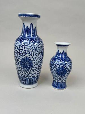 two blue and white vases sitting next to each other on a table