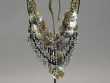 necklace made of shells and pearls on a stand on a gray background
